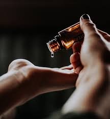 Gocce di olio essenziale versate sulla mano per aromaterapia e benessere naturale